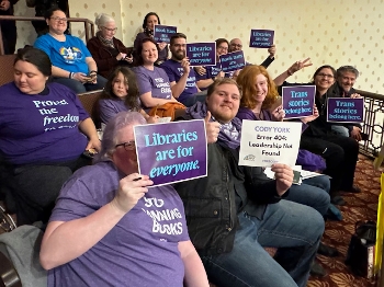 RCLS supporters holding signs at board meeting